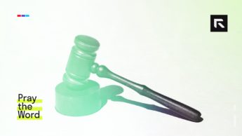 This picture features a gavel on a white table.
