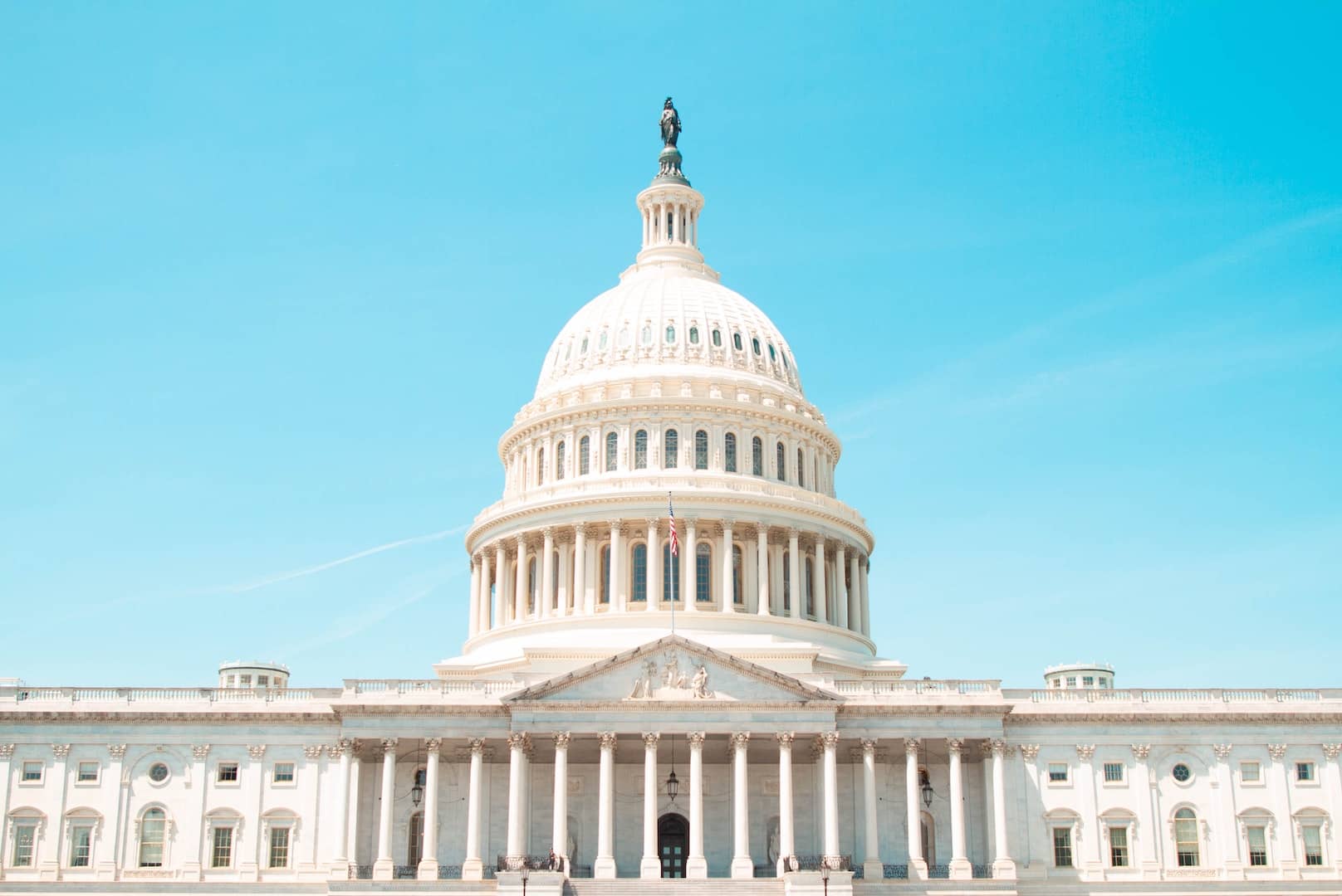 The front of the Capitol building in Washington D.C. and a blue sky.