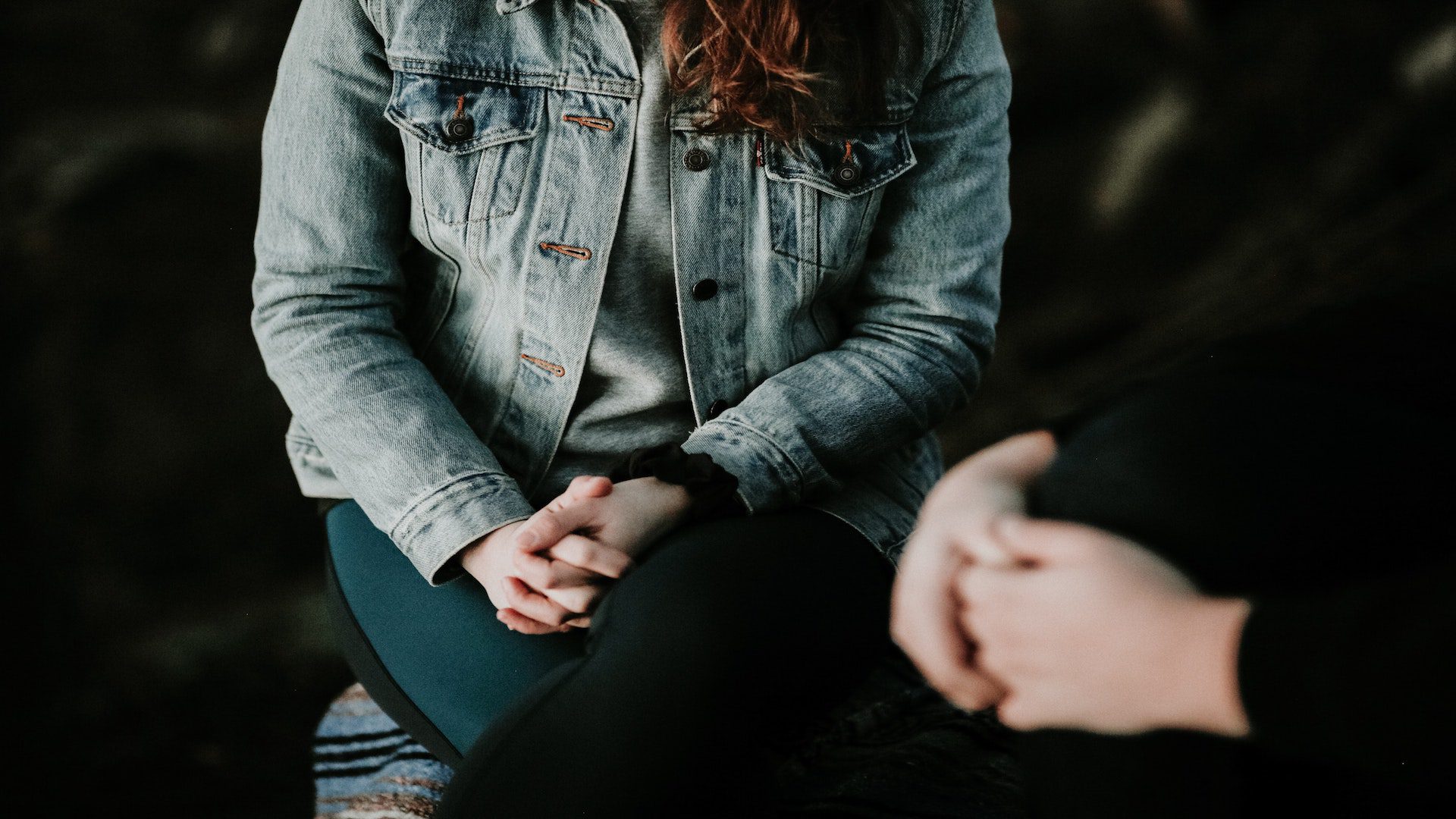 A woman and a man with their hands folded in prayer.