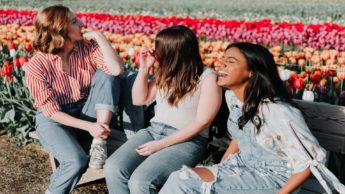 Three women at a flower field.