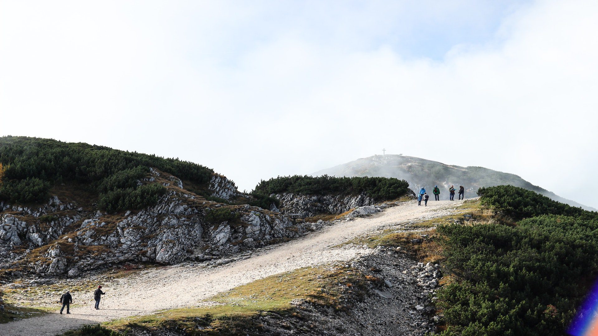 People walking on a dirt path on a hill.