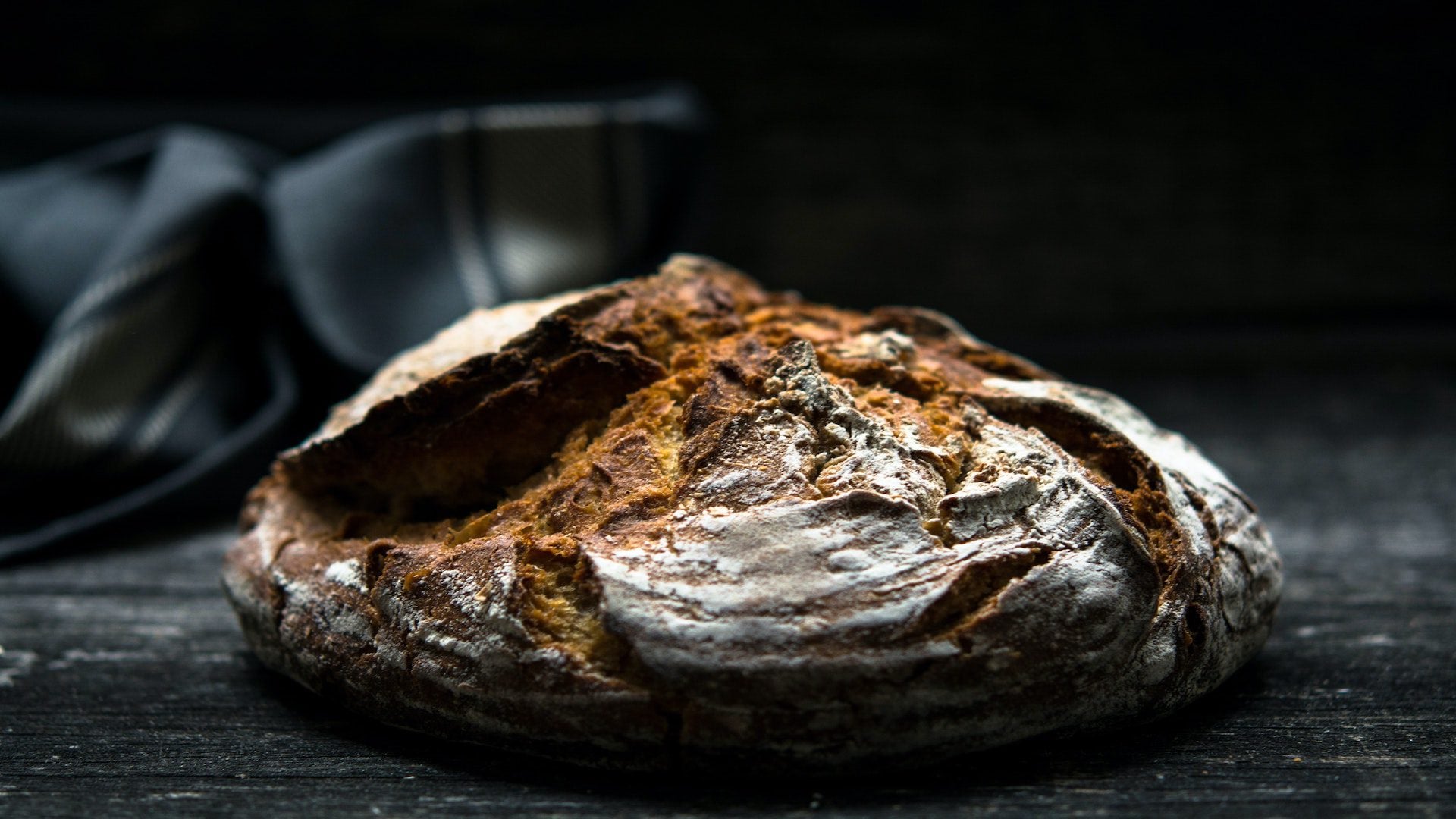 CIrcle loaf of bread on a black counter.