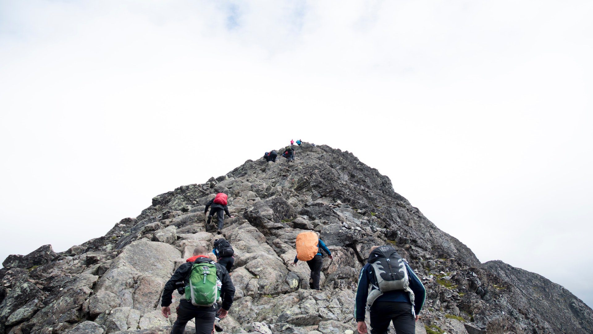 A group of people climbing a rocky mountain.