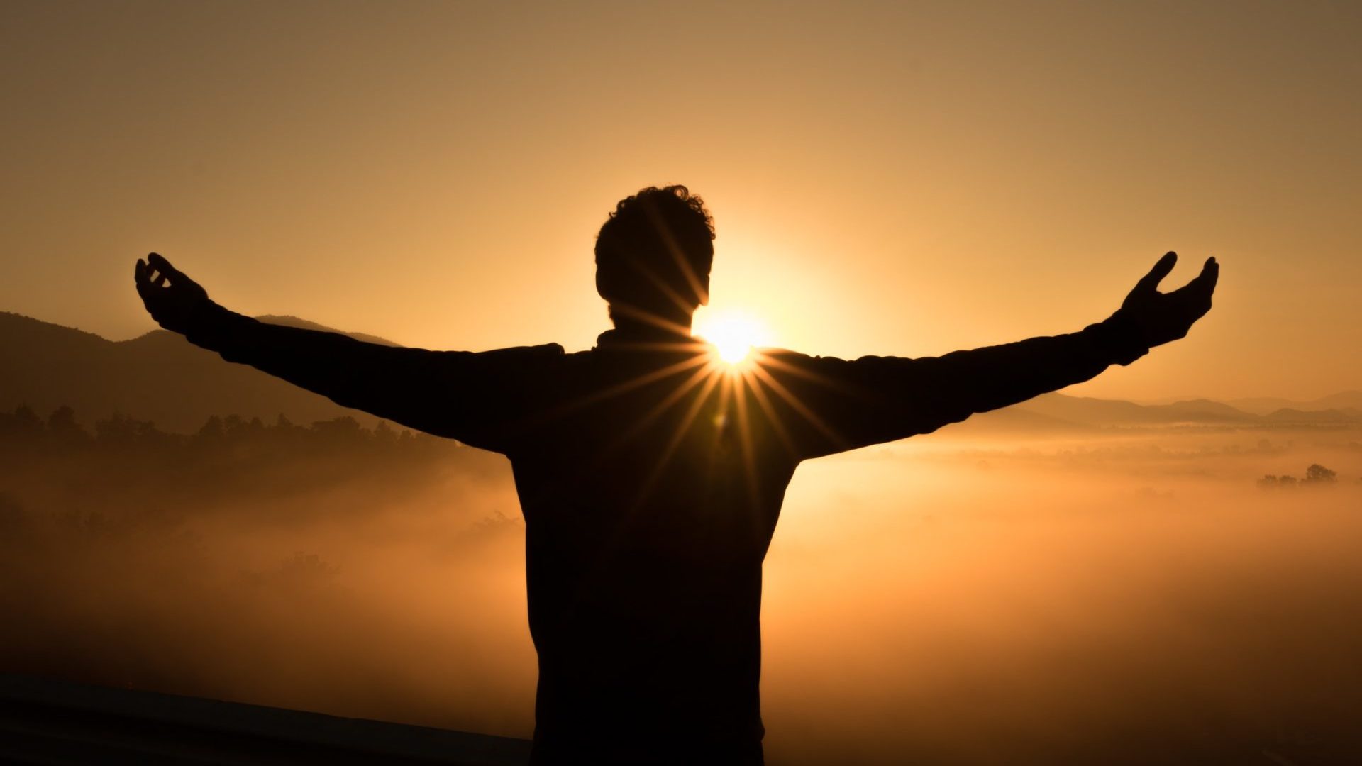 Silhouette of a person with their arms spread like an eagle.