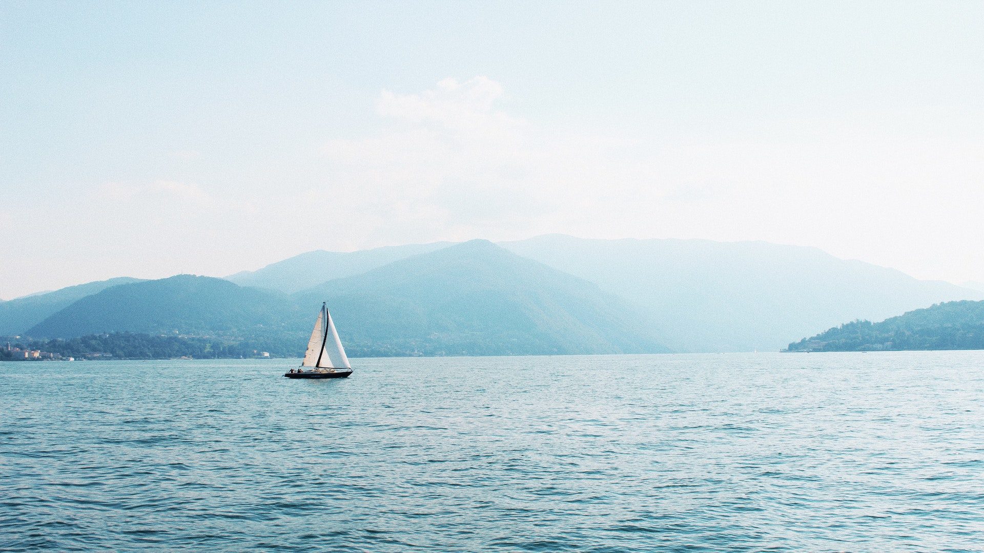 A sailboat in the middle of a lake.