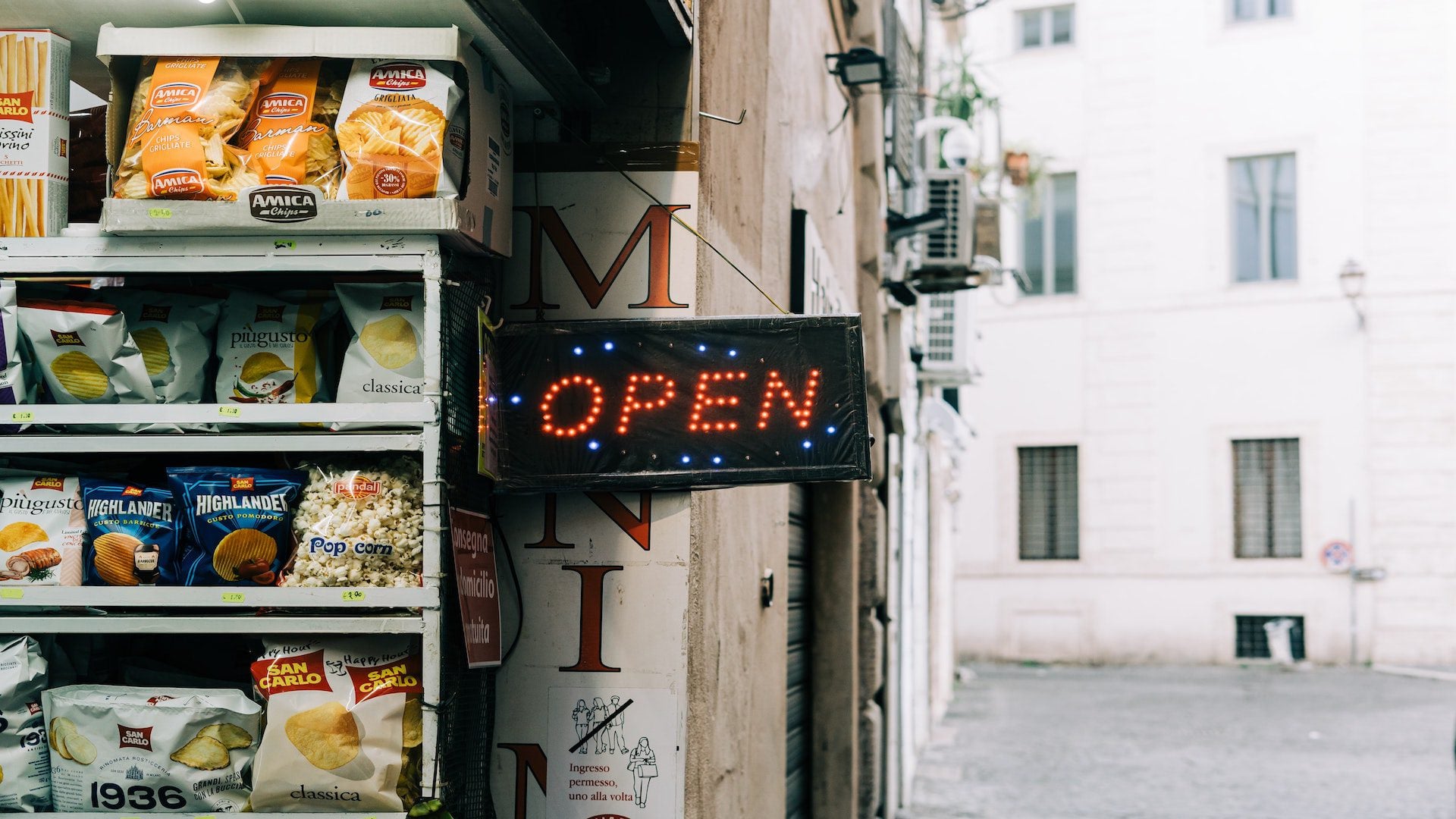 Neon sign saying open outside a mini market in Rome, Italy.
