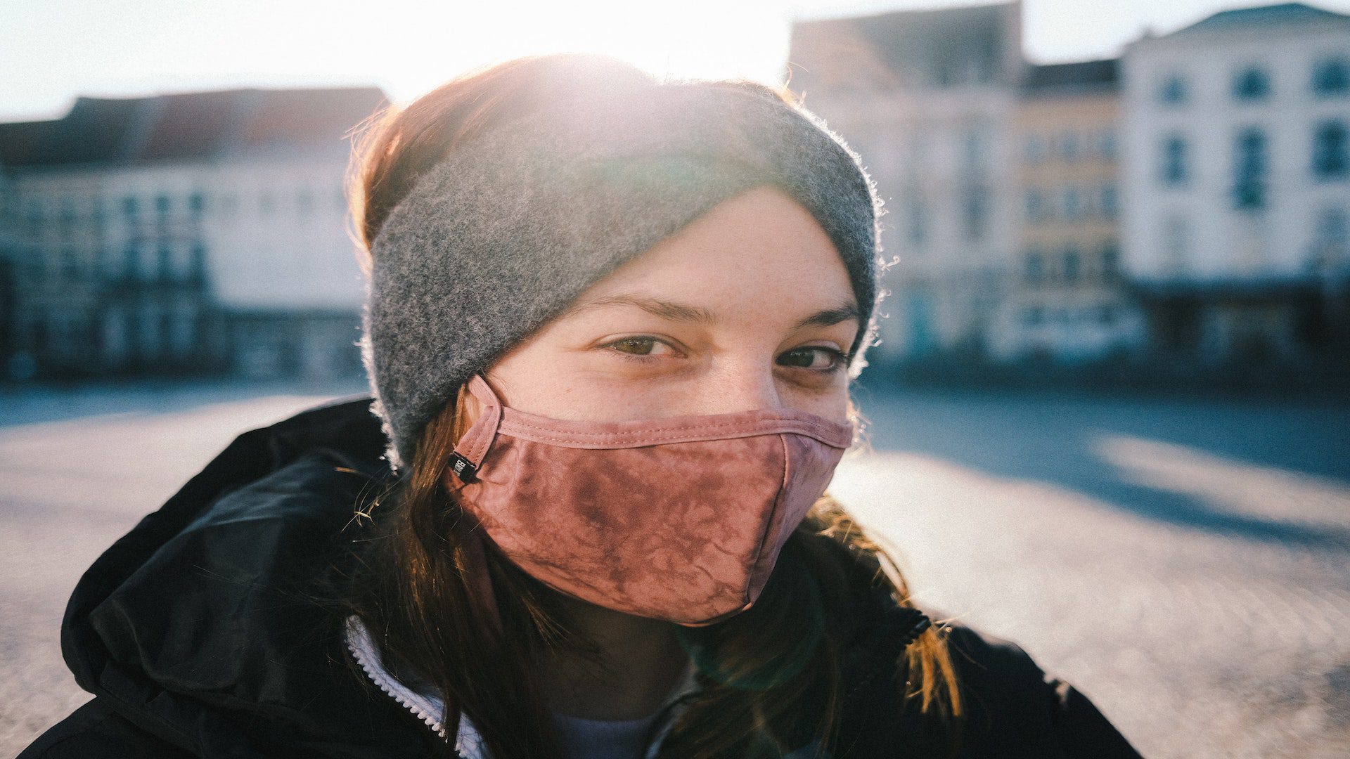 Woman outside in city with a face mask.