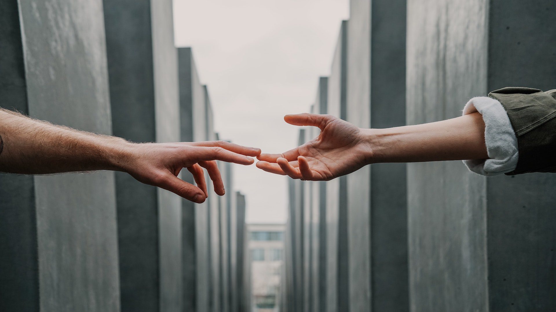 Two hands reaching out towards one another.