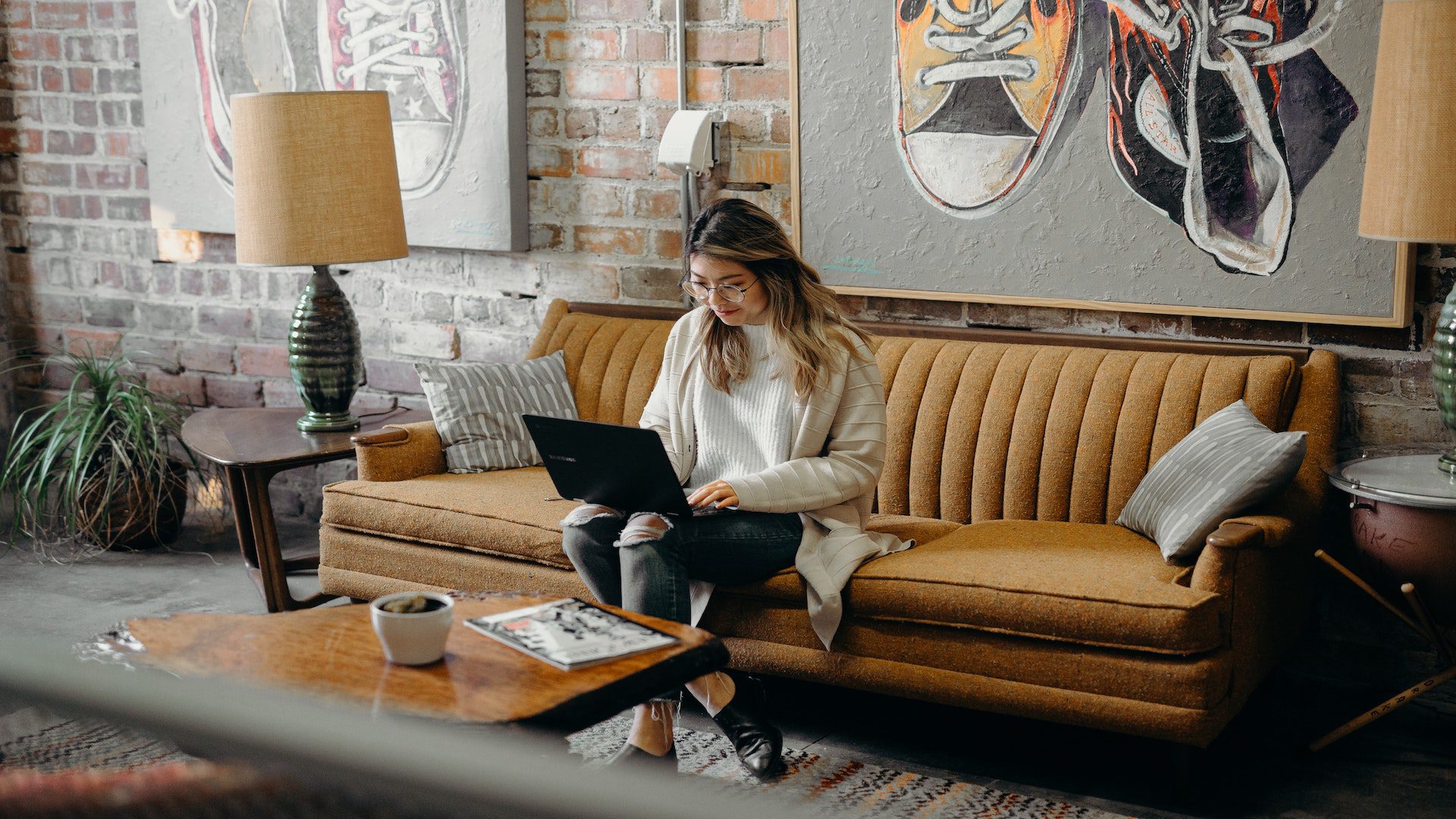 Woman sitting on a couch on her laptop.