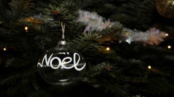 Noel globe ornament on a Christmas tree.