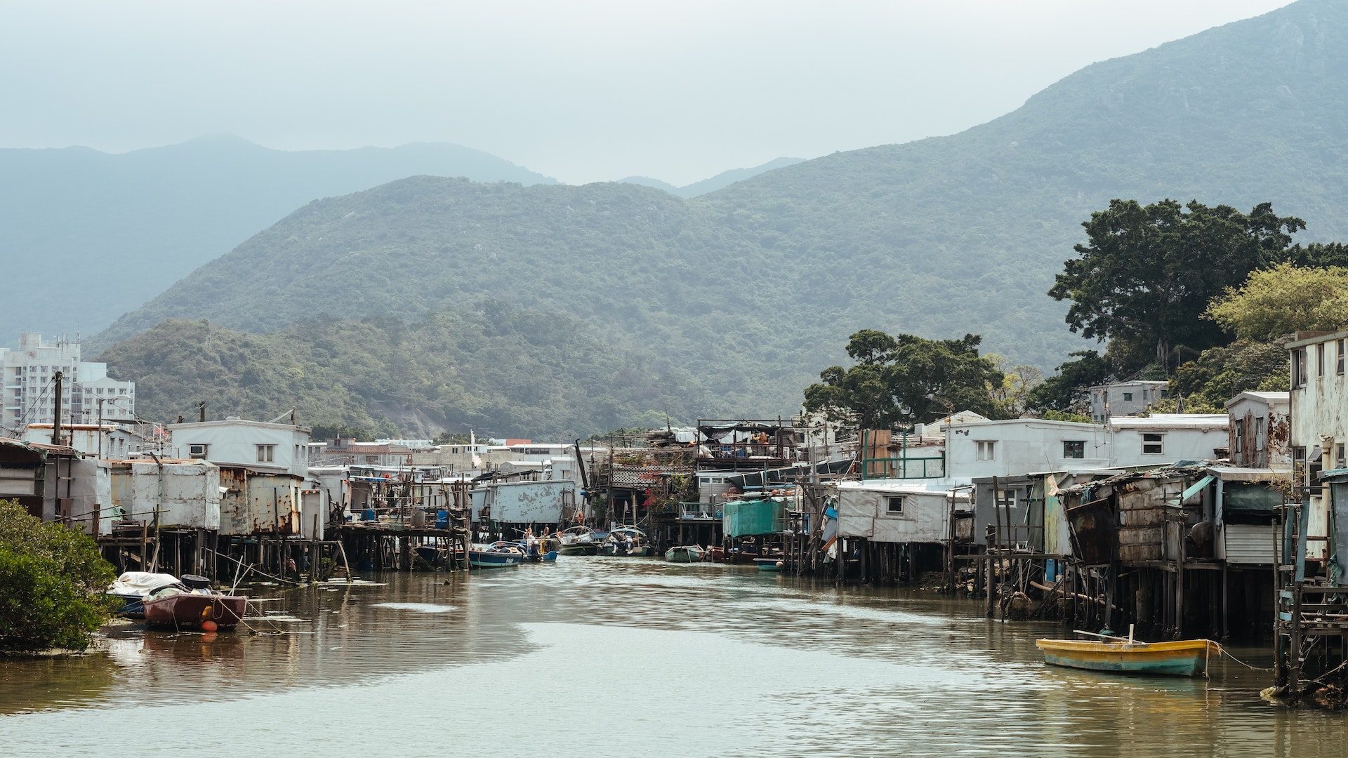 Wooden shanties along a river in an impoverished area.