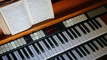 Organ with sheet music for the hymn "The Old Rugged Cross."