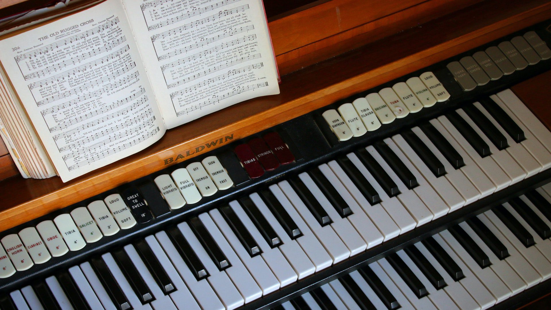 Organ with sheet music for the hymn "The Old Rugged Cross."