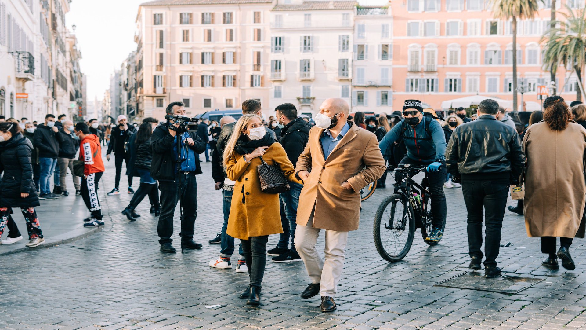 People with face masks walking on a city street in the winter.