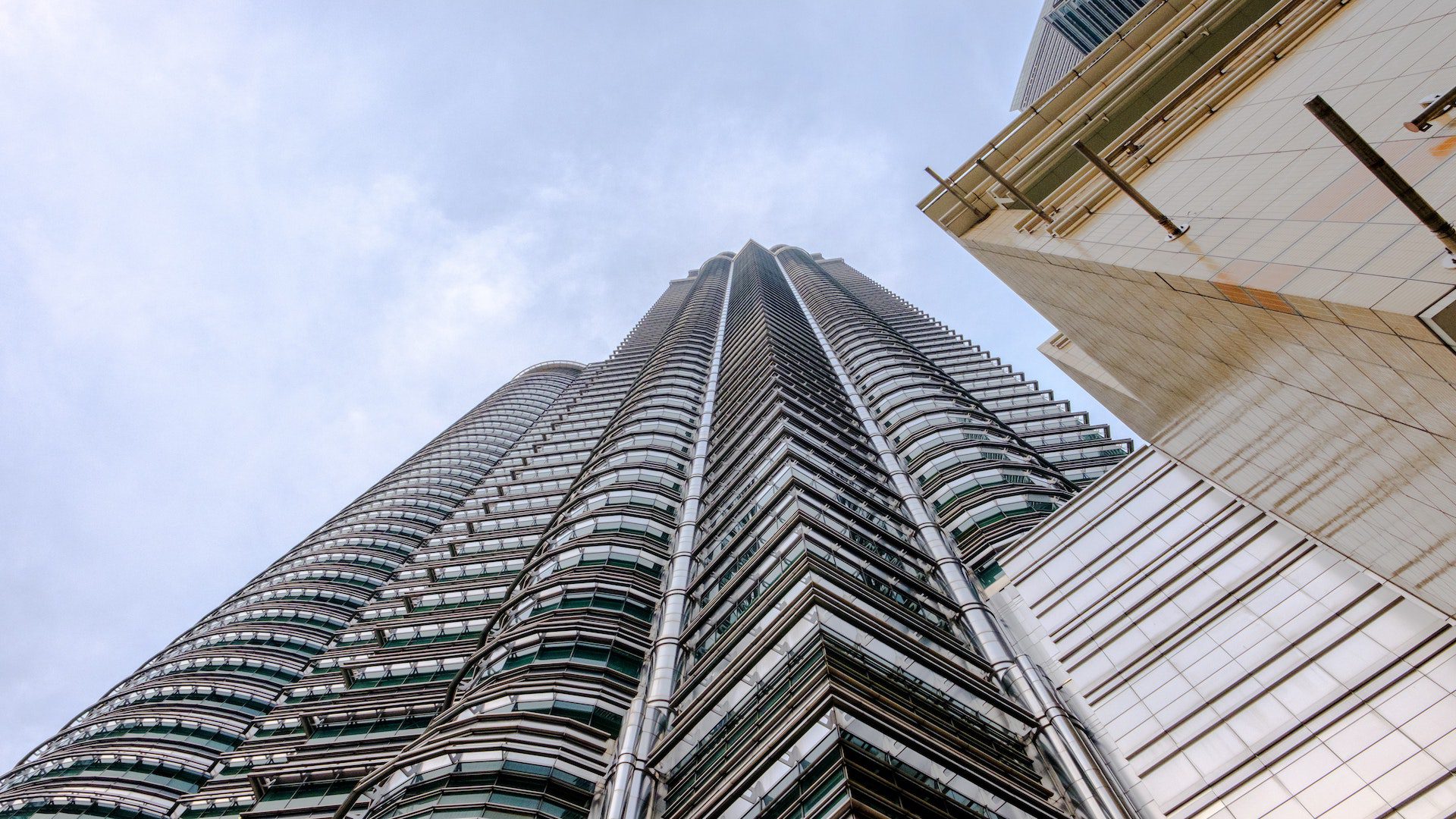 Low angle of white and gray high rises in a Malaysian city.