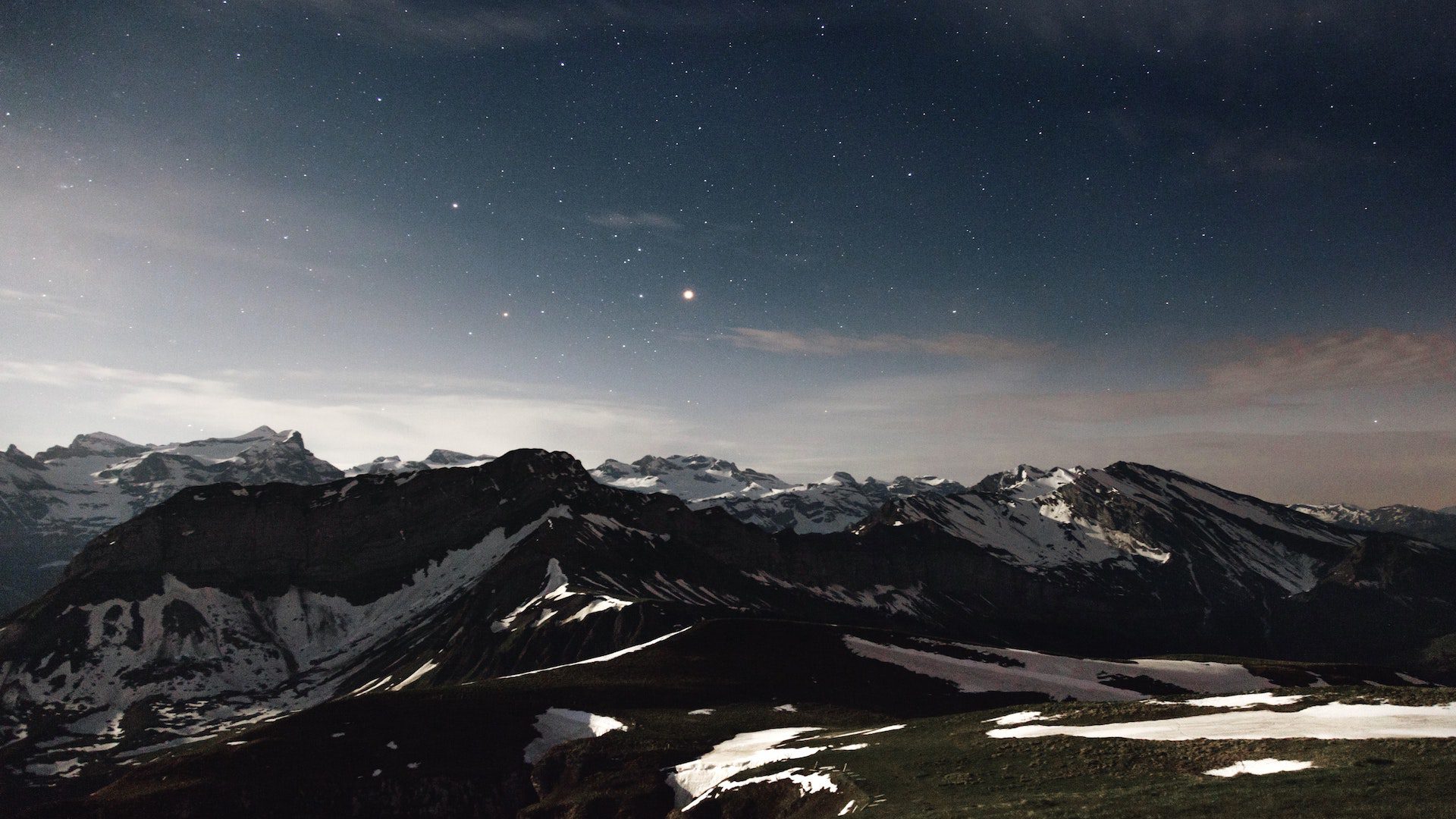 Snow covered mountains under a starry sky.