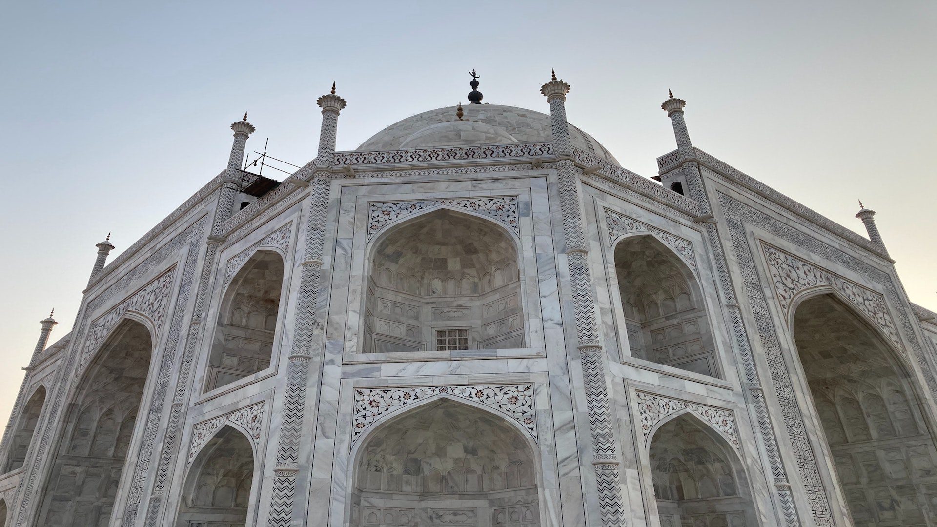 A white stone mosque under a blue sky.