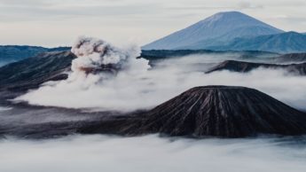 Smoke and clouds covering black volcanoes.