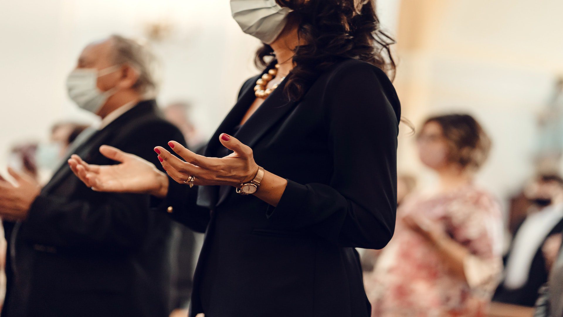 A group of people who have their hands raised and their palms exposed in worship.
