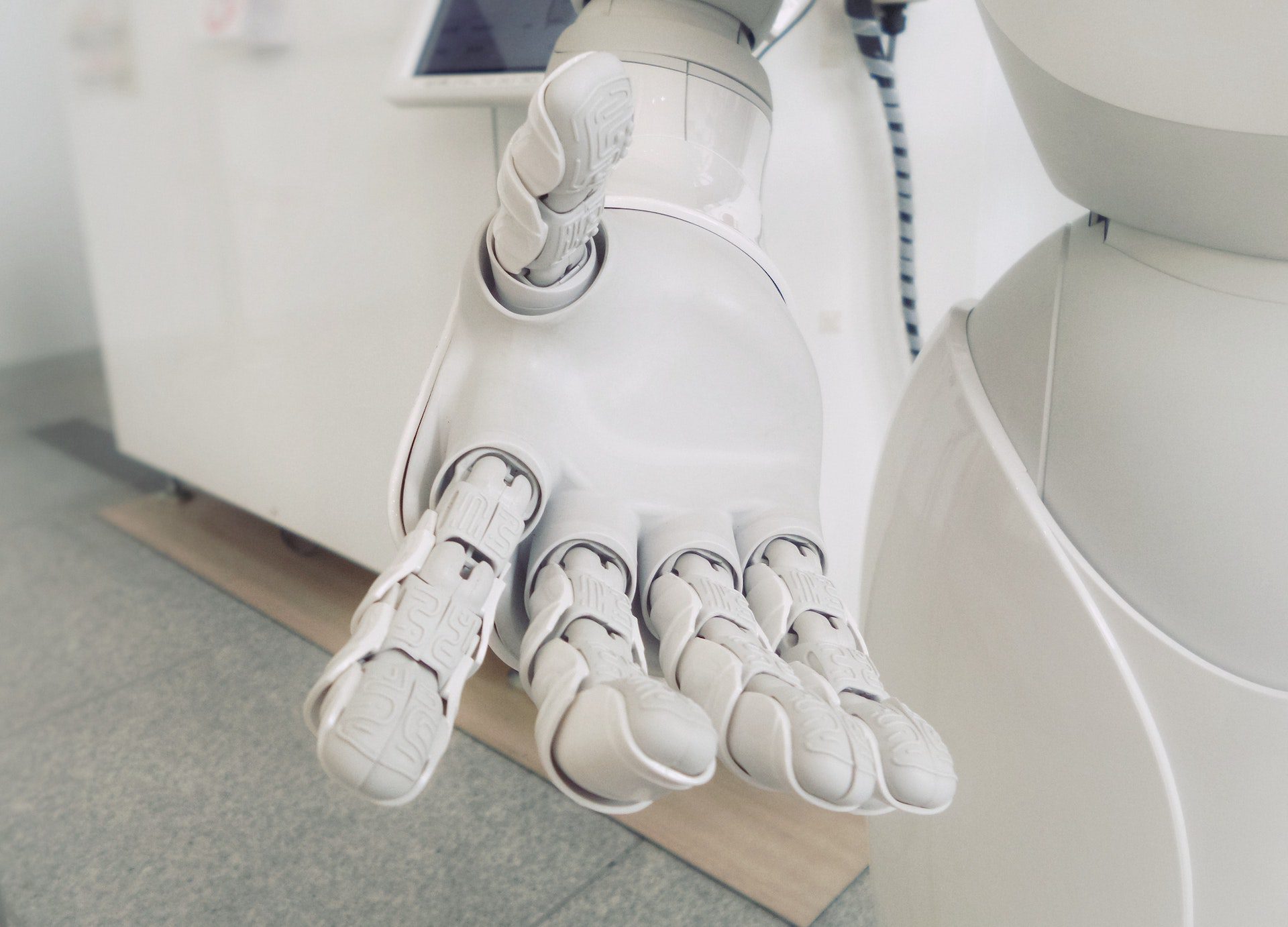 A white artificial hand stretches its hand out.