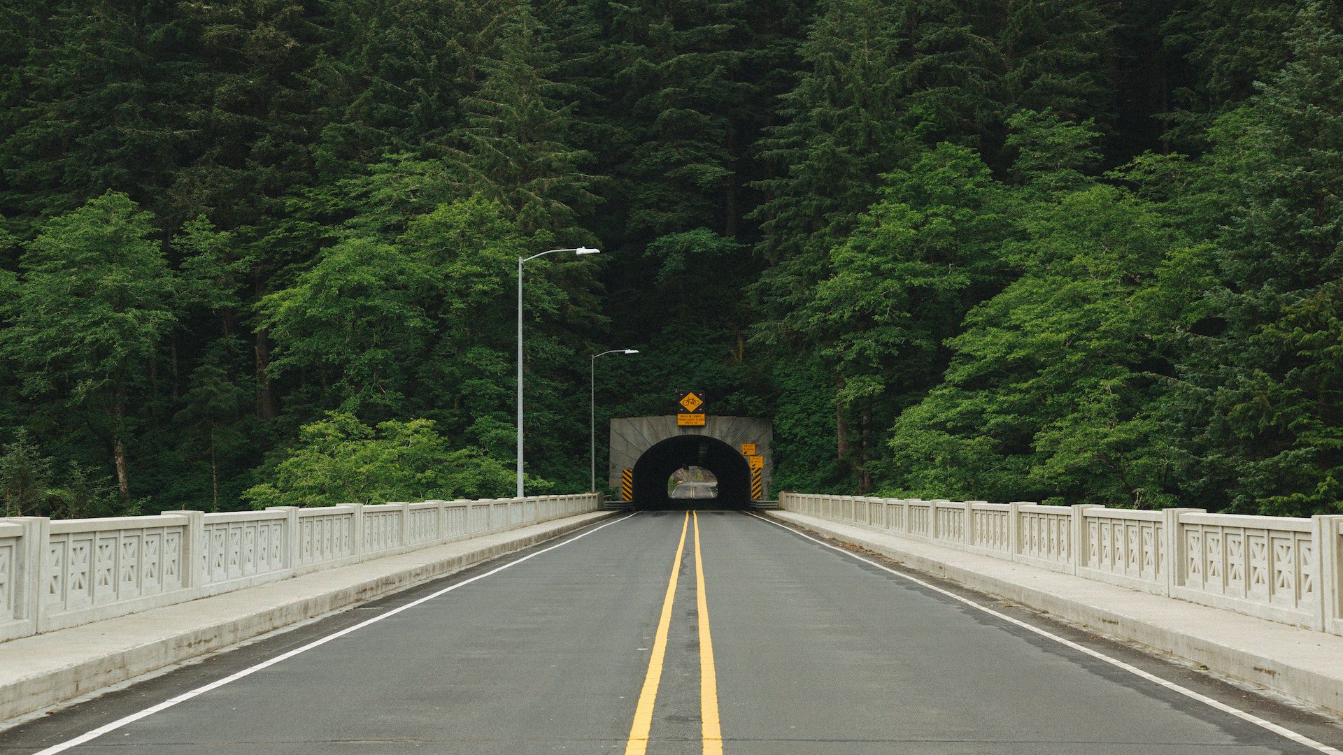 A road leading into a tunnel that cuts through the mountains.