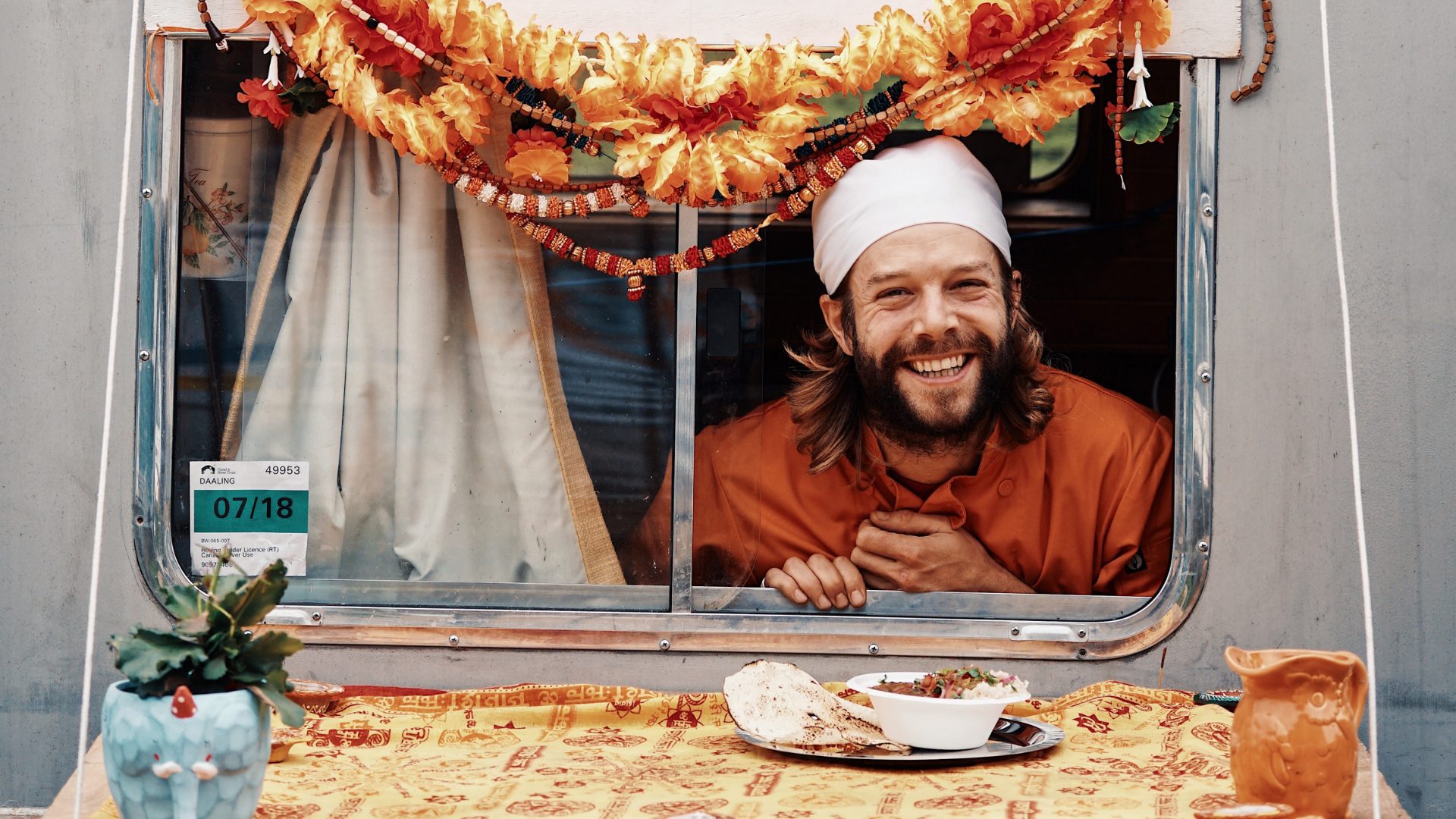 A man smiling inside his local restaurant in India.