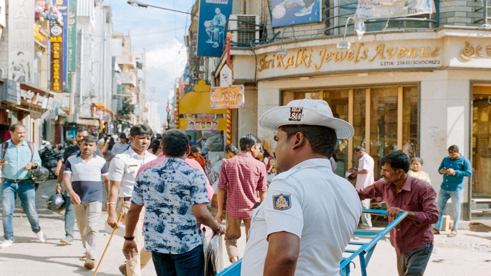 A busy street with people bustling about on a bright sunny day