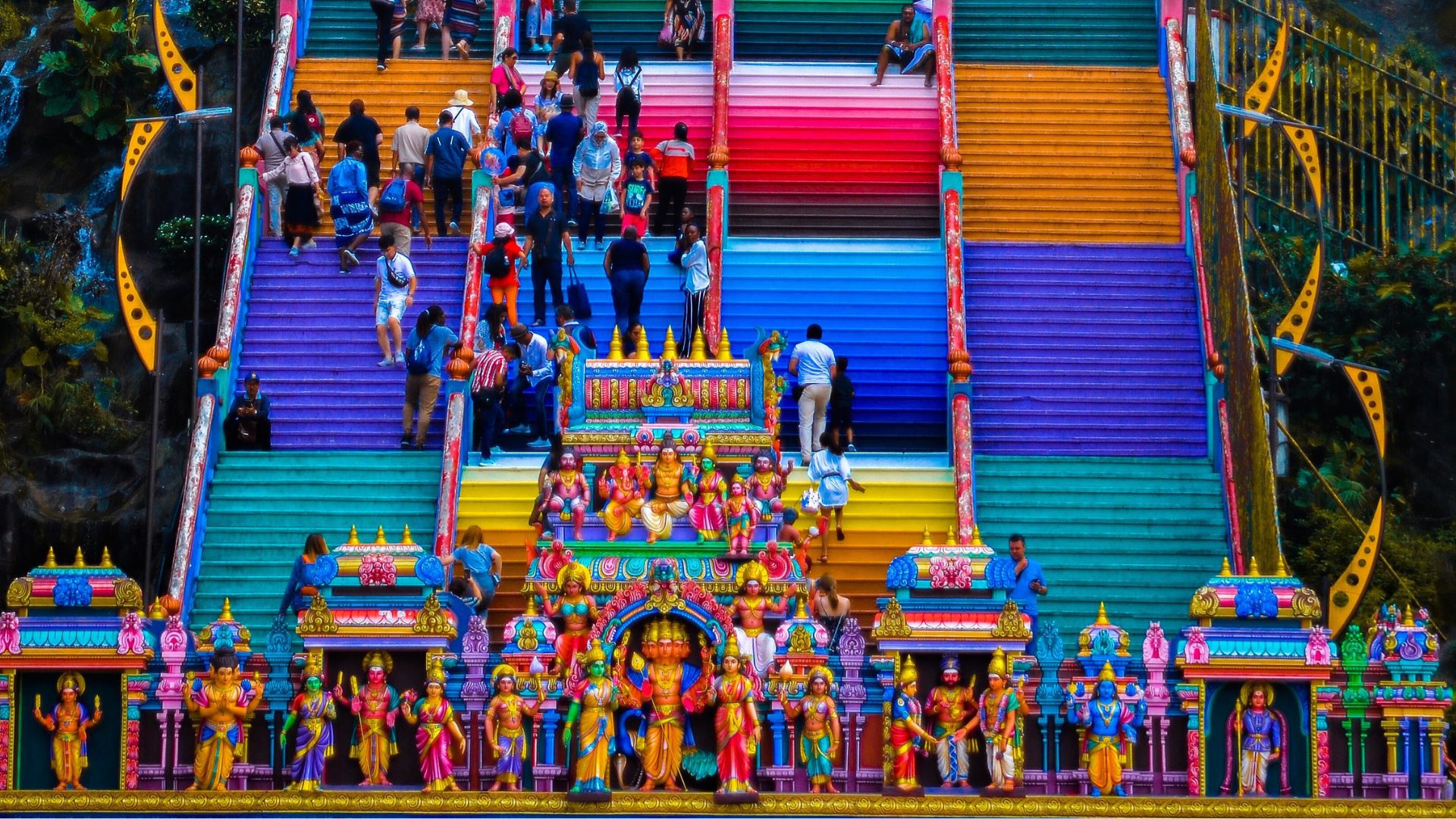 People walking up colorful stairs in Malaysia.