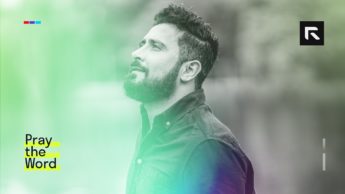 A Latino man stands and looks up into the sky.