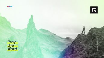 A hiker stands at the edge of a cliff.