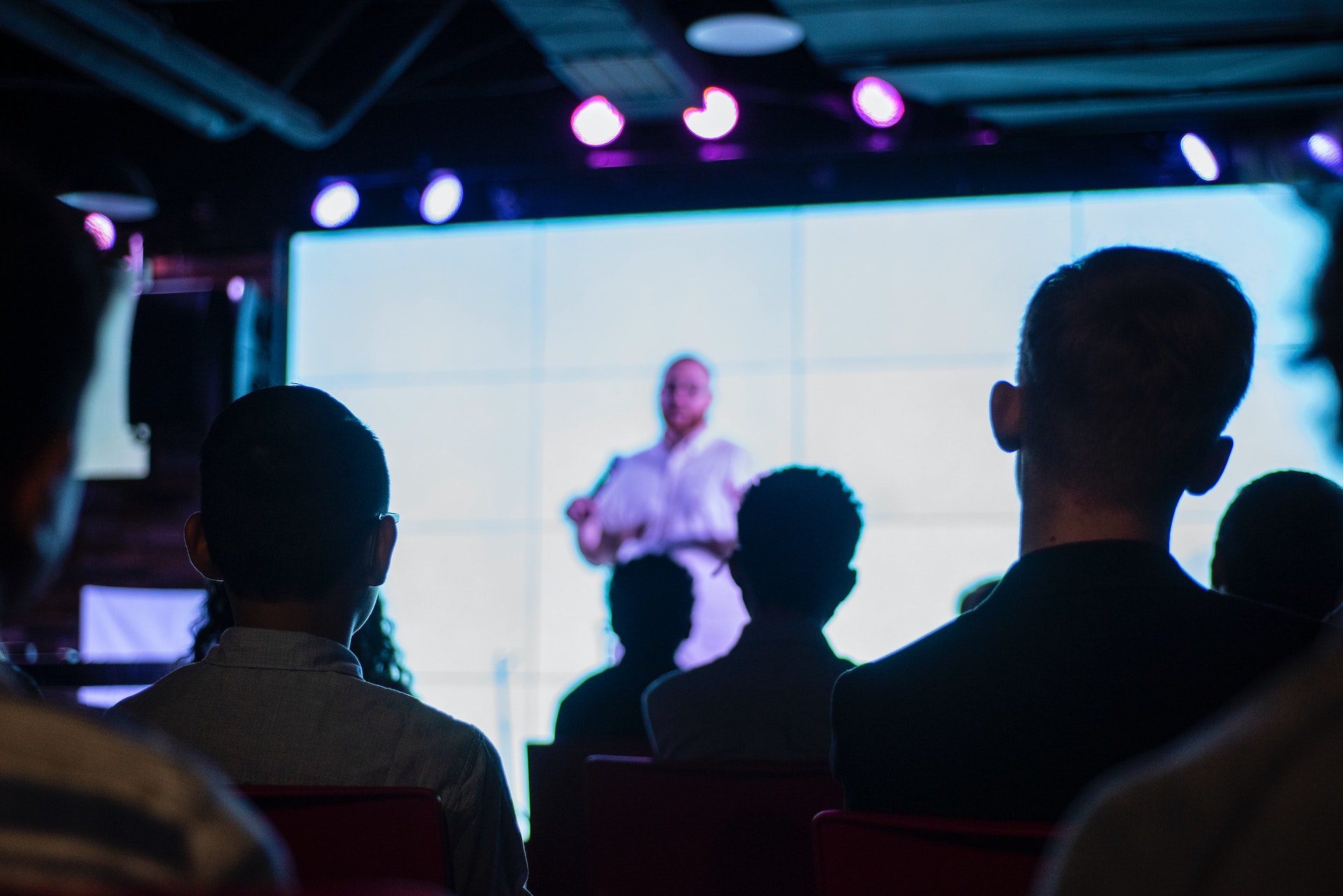 A youth pastor stands before the youth group.