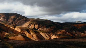 Brown mountains under a cloudy sky.