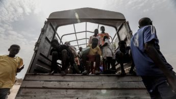 People climbing out the back of a bus.