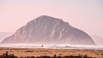 Person in ocean with a rock formation.