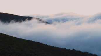 Clouds covering dark mountains.