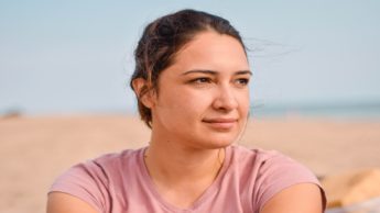 Woman in a pink shirt facing right.