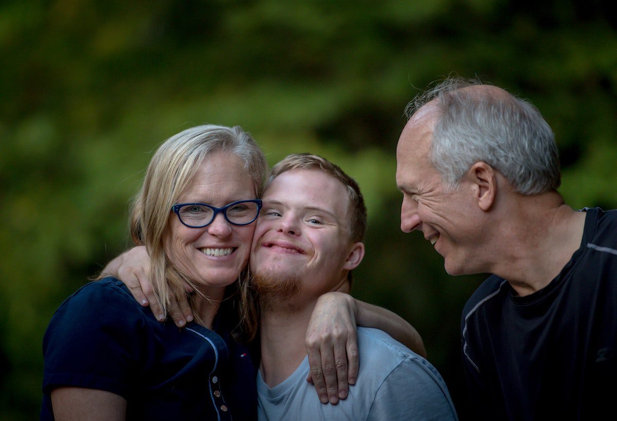 A family hugs their son with Down Syndrome.