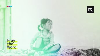 A small girl sits on the ground.