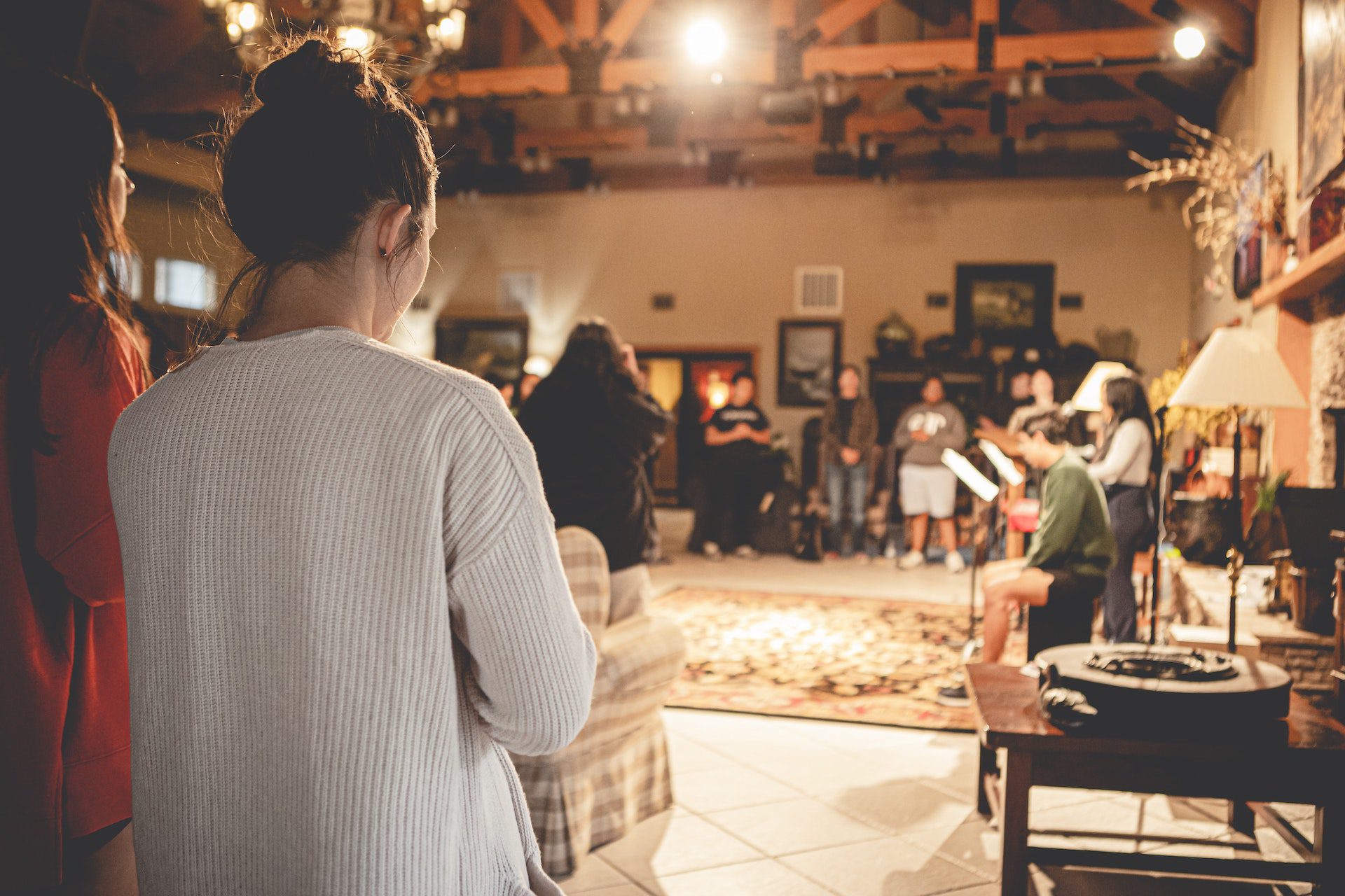 A group of people sit in a room singing.