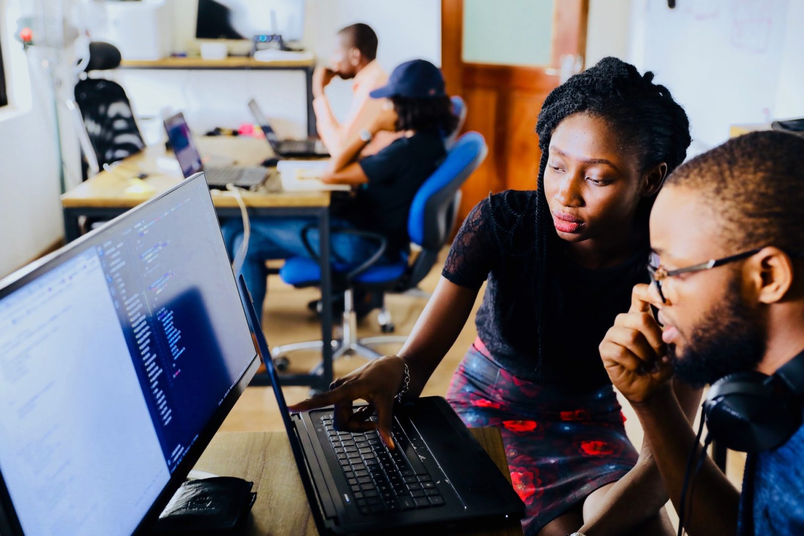 Two people sit and work on the computer.