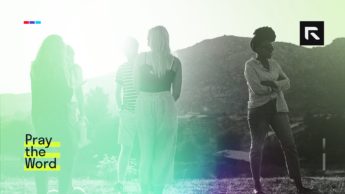 A group of people stand around.