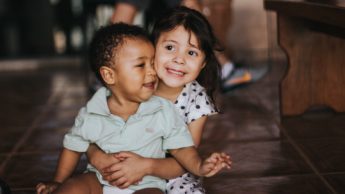 infant girl hugging boy