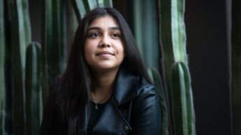 Young woman in a leather jacket in front of cactus