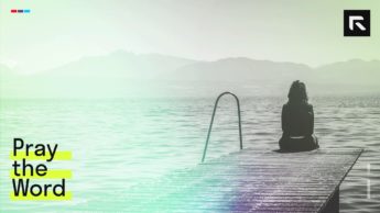 A woman sit on the edge of a dock staring at the lake during daytime