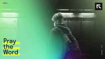 man in black jacket waiting at train station