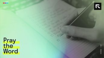 person writing to-do list on book