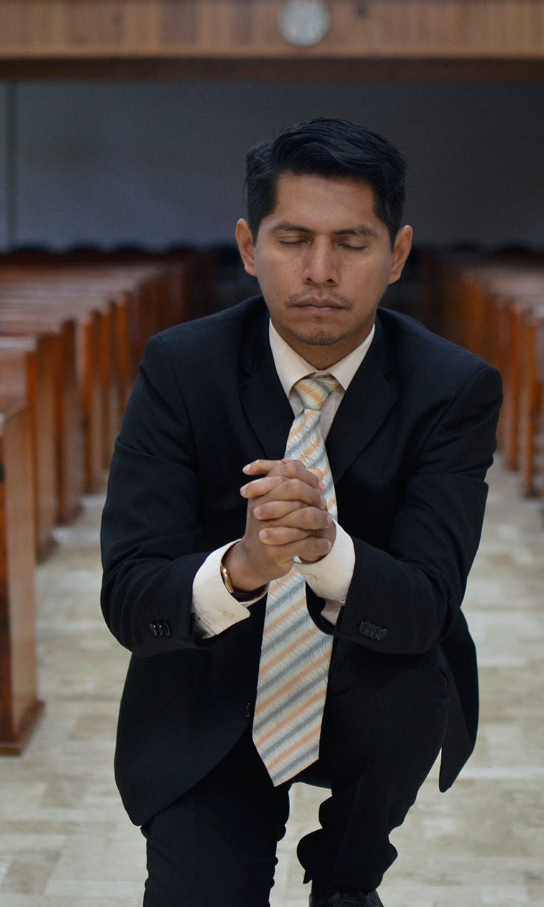 man kneeling in church praying
