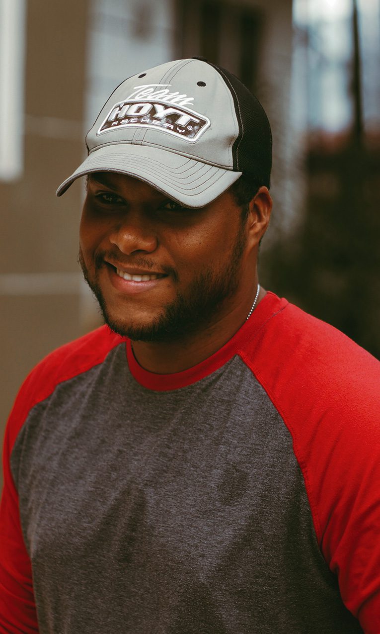man in red and gray crew neck long sleeve shirt wearing gray and white baseball cap