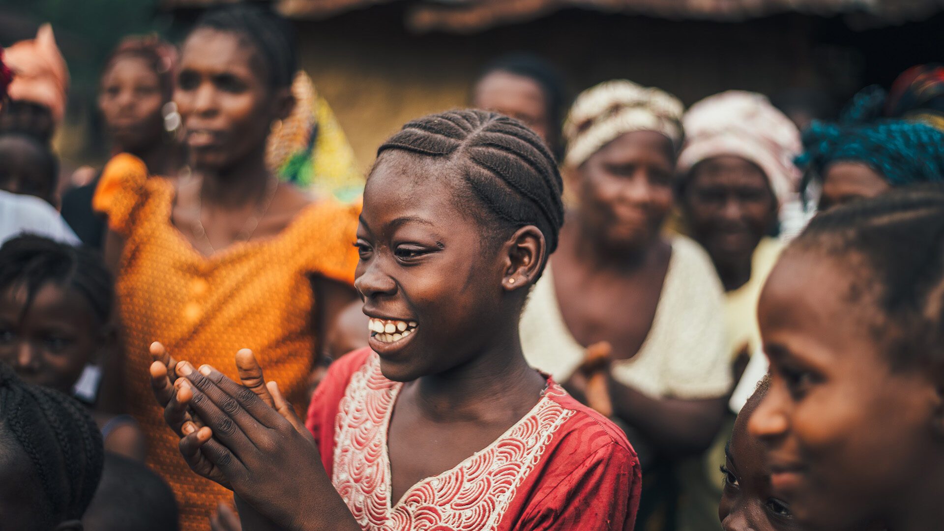 woman smiling sorrounded by a group of friends