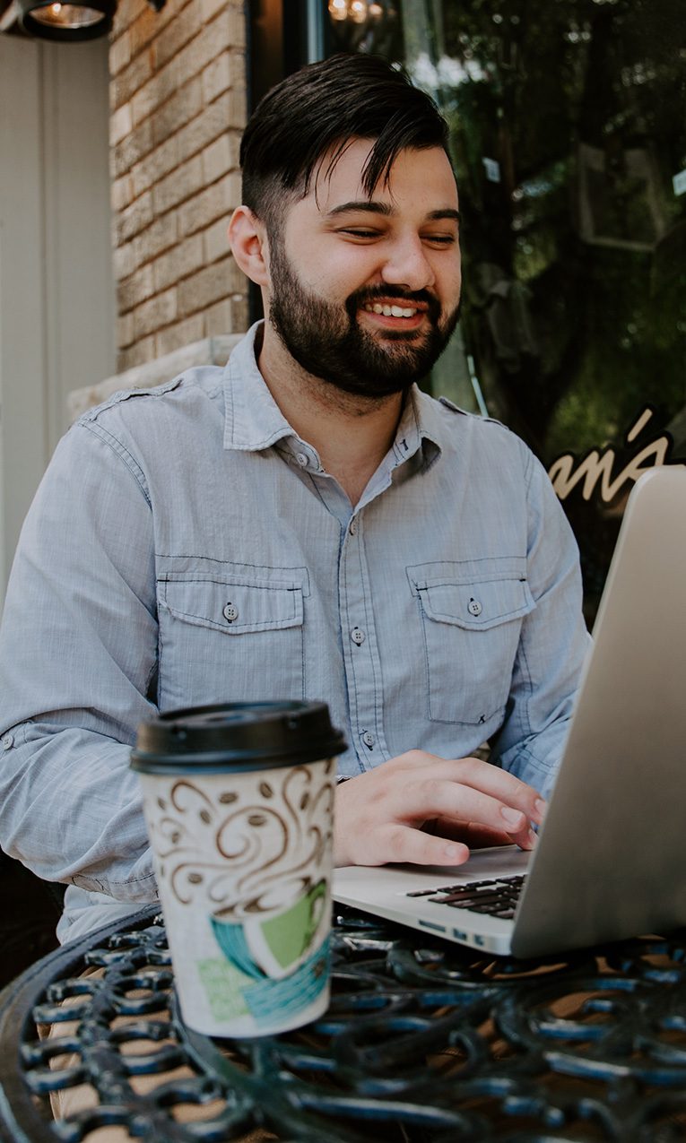 man using laptop in a cafe